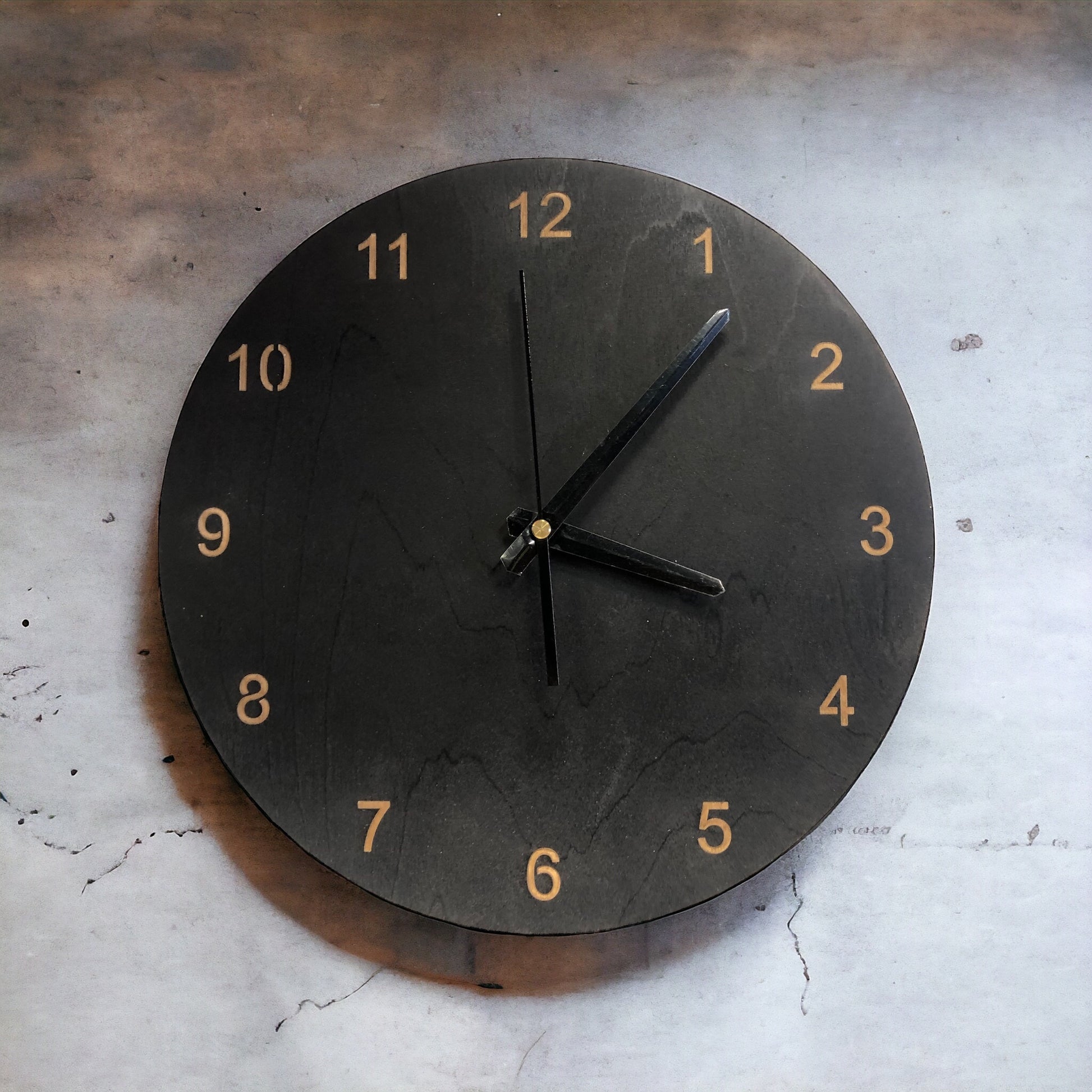 Kello-kaiverretuilla-numeroilla-mustat-viisarit-musta